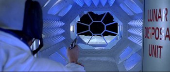 Movie still from “Austin Powers: The Spy Who Shagged Me” (1999), directed by Jay Roach – A person holding a gun in front of an open window; Wide shot, Overhead angle