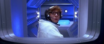 Movie still from “Austin Powers: The Spy Who Shagged Me” (1999), directed by Jay Roach – A man in a white jacket with headphones on his head; Medium shot, Overhead angle