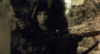 Movie still from “Avalon” (2001), directed by Mamoru Oshii – A woman holding a rifle in a cave; Close Up shot, Low angle