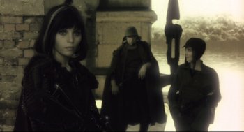 Movie still from “Avalon” (2001), directed by Mamoru Oshii – A group of people standing next to each other on a street; Medium shot, Low angle