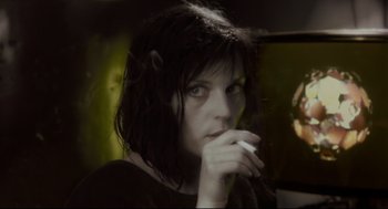 Movie still from “Avalon” (2001), directed by Mamoru Oshii – A person holding a cigarette in her mouth; Close Up shot, Over the shoulder angle