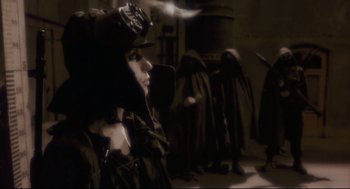 Movie still from “Avalon” (2001), directed by Mamoru Oshii – A group of people standing in a dark room; Medium shot, Over the shoulder angle