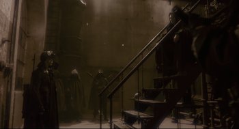 Movie still from “Avalon” (2001), directed by Mamoru Oshii – A group of people walking up a set of stairs; Wide shot, Low angle