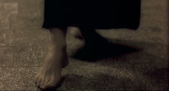 Movie still from “Avalon” (2001), directed by Mamoru Oshii – A person walking barefoot on the ground; Extreme Close Up shot, High angle