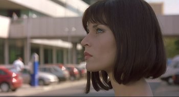 Movie still from “Avalon” (2001), directed by Mamoru Oshii – A person's face with cars in the background; Close Up shot, Low angle