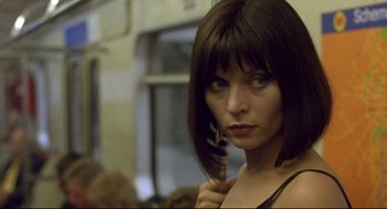 Movie still from “Avalon” (2001), directed by Mamoru Oshii – A woman holding a hair brush in front of her face; Close Up shot, Low angle