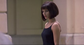 Movie still from “Avalon” (2001), directed by Mamoru Oshii – A woman in a black dress is looking to her left; Close Up shot, Over the shoulder angle
