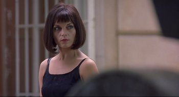 Movie still from “Avalon” (2001), directed by Mamoru Oshii – A woman in a black dress looking at the camera; Close Up shot, Over the shoulder angle