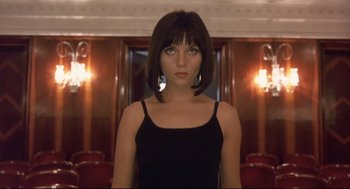 Movie still from “Avalon” (2001), directed by Mamoru Oshii – A woman in a black top standing in front of a mirror; Close Up shot, Low angle