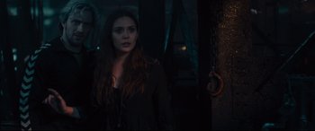 Movie still from “Avengers: Age of Ultron” (2015), directed by Joss Whedon – A woman standing in a dark room with her eyes wide open; Medium shot, Over the shoulder angle