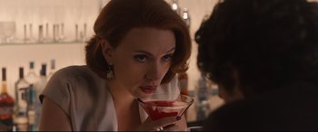 Movie still from “Avengers: Age of Ultron” (2015), directed by Joss Whedon – A beautiful woman holding a drink in her hand; Close Up shot, Over the shoulder angle