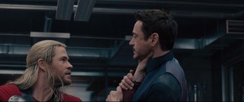 Movie still from “Avengers: Age of Ultron” (2015), directed by Joss Whedon – A man is holding a tie around his neck; Close Up shot, Over the shoulder angle