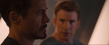 Movie still from “Avengers: Age of Ultron” (2015), directed by Joss Whedon – Two men are looking at each other in the dark; Close Up shot, Over the shoulder angle