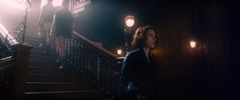 Movie still from “Avengers: Age of Ultron” (2015), directed by Joss Whedon – A woman standing in front of a set of stairs at night; Medium shot, Low angle