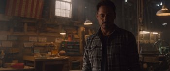 Movie still from “Avengers: Age of Ultron” (2015), directed by Joss Whedon – A person wearing a plaid shirt in a room; Medium shot, Over the shoulder angle