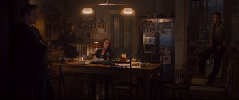 Movie still from “Avengers: Age of Ultron” (2015), directed by Joss Whedon – A woman sitting at a dining table with a beer; Wide shot, High angle