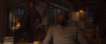Movie still from “Avengers: Age of Ultron” (2015), directed by Joss Whedon – A man with a eye patch sitting at a table in front of another man in a kitchen; Medium shot, Over the shoulder angle