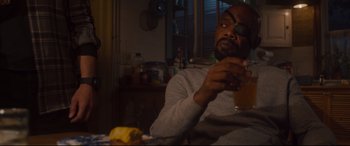 Movie still from “Avengers: Age of Ultron” (2015), directed by Joss Whedon – A man sitting at a dining table looking at his cell phone; Medium shot, High angle