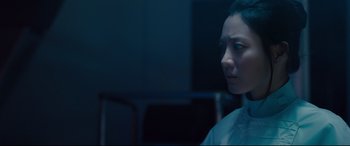 Movie still from “Avengers: Age of Ultron” (2015), directed by Joss Whedon – A woman is looking at the camera in a dark room; Close Up shot, Over the shoulder angle