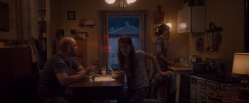 Movie still from “Avengers: Age of Ultron” (2015), directed by Joss Whedon – Three people are sitting at a table in a room; Wide shot, Over the shoulder angle