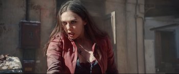 Movie still from “Avengers: Age of Ultron” (2015), directed by Joss Whedon – A woman in a red leather jacket with a knife in her mouth; Medium shot, Over the shoulder angle