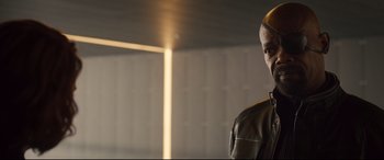 Movie still from “Avengers: Age of Ultron” (2015), directed by Joss Whedon – A man in a leather jacket standing next to a wall; Close Up shot, Over the shoulder angle