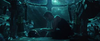 Movie still from “Avengers: Endgame” (2019), directed by Anthony Russo – A man sitting on the ground in front of a cross; Wide shot, High angle