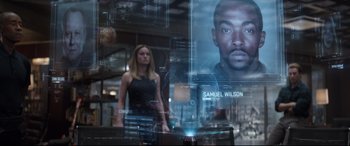 Movie still from “Avengers: Endgame” (2019), directed by Anthony Russo – A woman standing in front of an image of a man; Close Up shot, Low angle