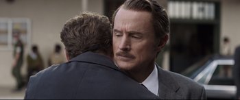 Movie still from “Avengers: Endgame” (2019), directed by Anthony Russo – A man in a business suit hugging another man in a business suit; Close Up shot, Over the shoulder angle