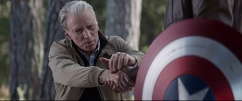 Movie still from “Avengers: Endgame” (2019), directed by Anthony Russo – An older man is holding the arm of a captain america's shield; Close Up shot, Over the shoulder angle
