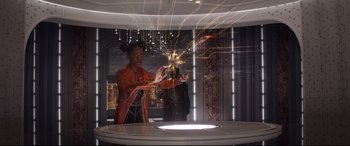 Movie still from “Avengers: Infinity War” (2018), directed by Anthony Russo – A woman in an orange dress is holding a sparkler; Medium shot, Over the shoulder angle