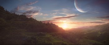 Movie still from “Avengers: Infinity War” (2018), directed by Anthony Russo – The sun is setting over a lush green hillside; Extreme Wide shot, High angle