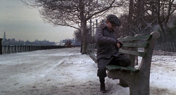 Movie still from “Awakenings” (1990), directed by Penny Marshall – A man sitting on top of a wooden bench in the snow; Wide shot, High angle