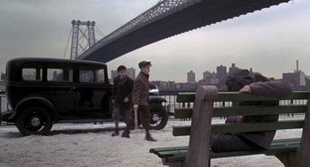 Movie still from “Awakenings” (1990), directed by Penny Marshall – Two young men walking on a beach under a bridge; Wide shot, Over the shoulder angle