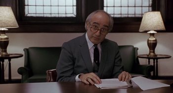 Movie still from “Awakenings” (1990), directed by Penny Marshall – An older man sitting at a table reading a paper; Medium shot, High angle
