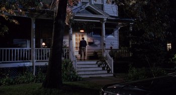 Movie still from “Awakenings” (1990), directed by Penny Marshall – A man standing on the steps of a house at night; Wide shot, High angle