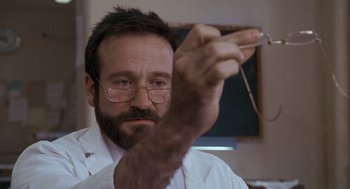 Movie still from “Awakenings” (1990), directed by Penny Marshall – A person wearing glasses and a lab coat; Close Up shot, Over the shoulder angle