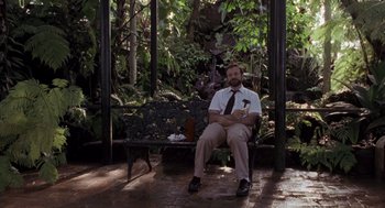 Movie still from “Awakenings” (1990), directed by Penny Marshall – A man sitting on top of a wooden bench; Wide shot, Low angle