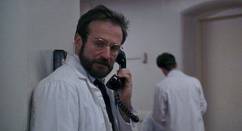 Movie still from “Awakenings” (1990), directed by Penny Marshall – A man in a white lab coat talking on a phone; Close Up shot, Low angle
