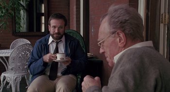 Movie still from “Awakenings” (1990), directed by Penny Marshall – A man sitting in a chair with a cup of coffee; Medium shot, Over the shoulder angle