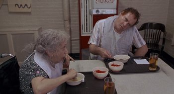 Movie still from “Awakenings” (1990), directed by Penny Marshall – A man and a woman sitting at a table with bowls of food; Medium shot, High angle