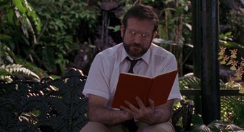 Movie still from “Awakenings” (1990), directed by Penny Marshall – A man sitting on the ground reading a book; Medium shot, Low angle