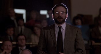 Movie still from “Awakenings” (1990), directed by Penny Marshall – A man in a suit and tie standing in front of a group of people; Close Up shot, Low angle