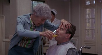 Movie still from “Awakenings” (1990), directed by Penny Marshall – An older woman is brushing a man's hair; Close Up shot, Over the shoulder angle