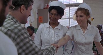 Movie still from “Awakenings” (1990), directed by Penny Marshall – A man and two nurses shaking hands in a room; Medium shot, Over the shoulder angle