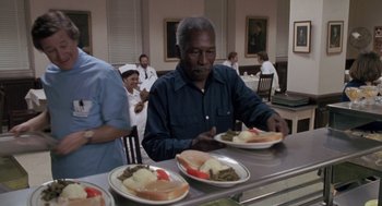 Movie still from “Awakenings” (1990), directed by Penny Marshall – An older man sitting at a table with plates of food; Medium shot, High angle