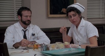 Movie still from “Awakenings” (1990), directed by Penny Marshall – A man and a woman sitting at a dinner table; Medium shot, Low angle