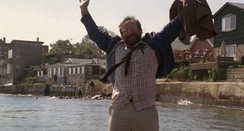 Movie still from “Awakenings” (1990), directed by Penny Marshall – A man standing in the middle of a river with his arms in the air; Medium shot, Low angle
