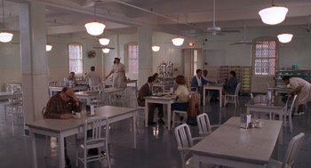 People are sitting at tables in a large dining hall