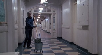 Movie still from “Awakenings” (1990), directed by Penny Marshall – A man in a hallway with a mop and bucket; Wide shot, Low angle